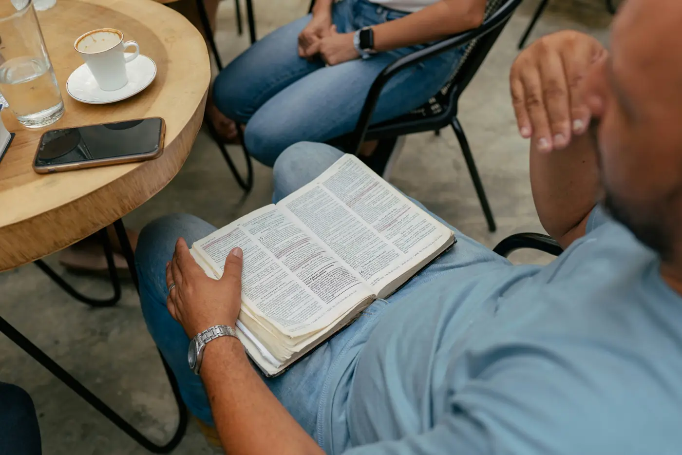 Varias personas sentadas alrededor de una mesa con Biblias abiertas